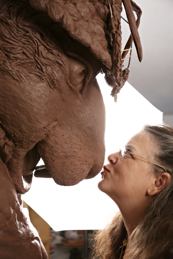 Texas artist kisses the nose of a clay sculpture