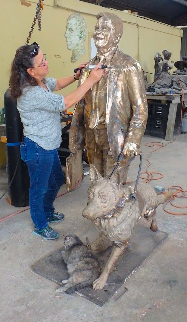johnturner26 Sculptor Bridgette Mongeon looks over the metal of a bronze statue